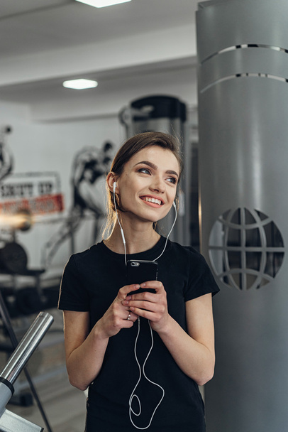 Beautiful girl in the gym with your phone - Foto, afbeelding