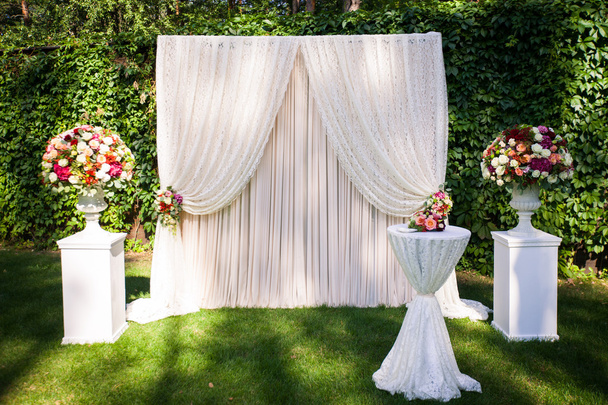 весільна арка з квітами на фоні зеленого листя
 - Фото, зображення