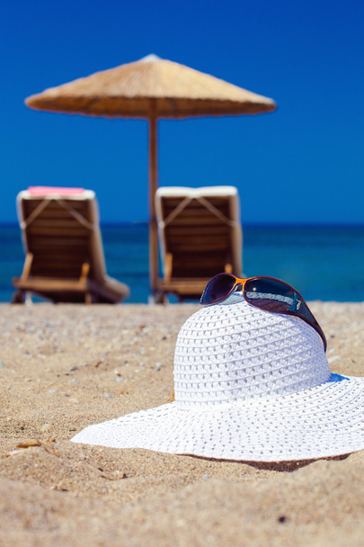 海と砂の上の帽子の青の色 - 写真・画像