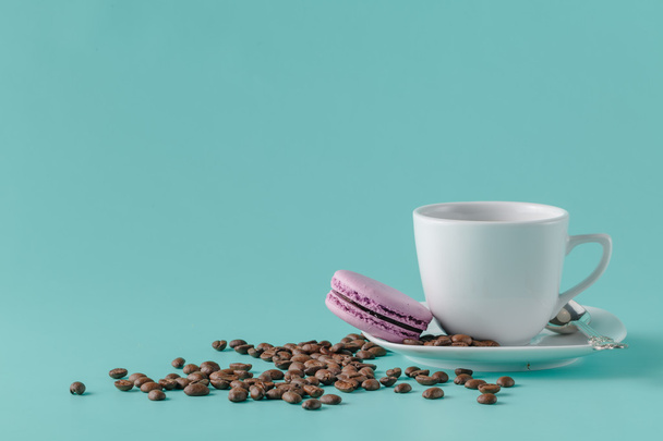 A cup of coffee on a saucer on a aquamarine background - Photo, Image