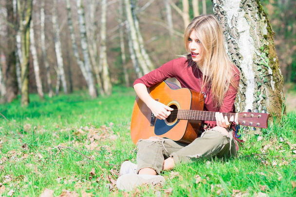Chica rubia toca la guitarra
  - Foto, imagen