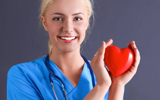 Doctor with stethoscope holding heart - Фото, изображение