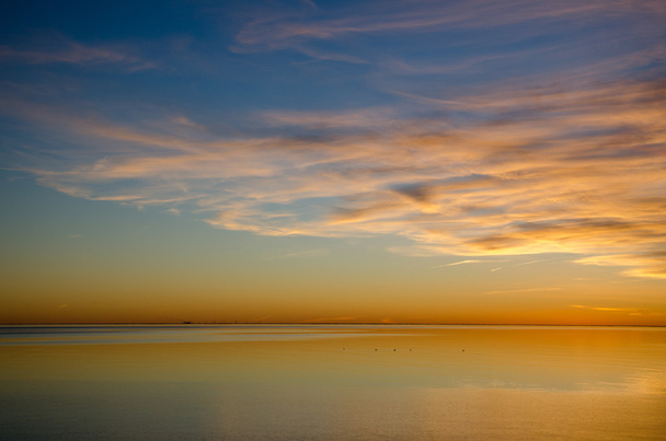 Värikäs auringonlasku täysin rauhallisella vedellä
 - Valokuva, kuva
