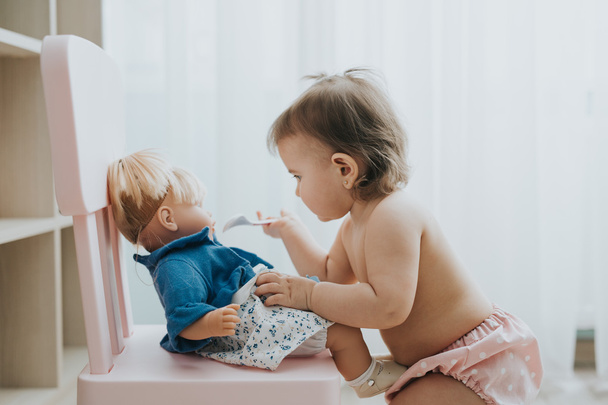 Cute baby girl playing in a white room in the morning with toys - Foto, Imagem