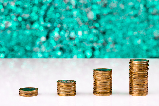 Pilhas de moedas mostrando um aumento em um fundo azul iluminado  - Foto, Imagem