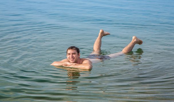 Hombre flotando en el Mar Muerto, Jordania
 - Foto, imagen