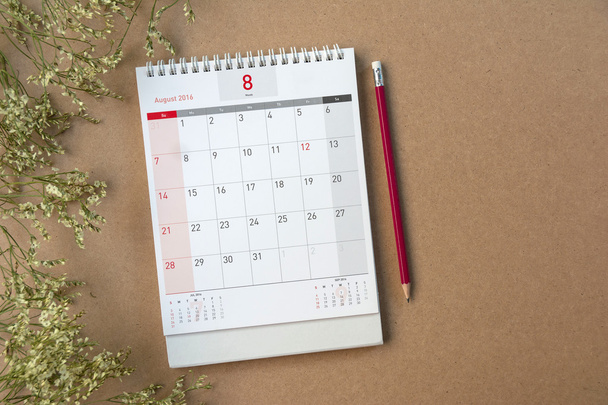 серпневий календар 2016 року і стара квітка на дерев'яному столі
  - Фото, зображення