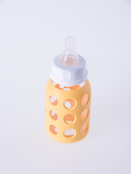 baby glass bottle or yellow baby bottles or background. - Foto, imagen