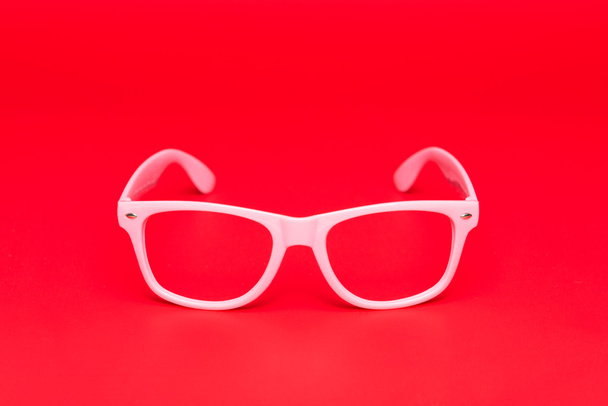 Розовые очки на красном фоне
 - Фото, изображение