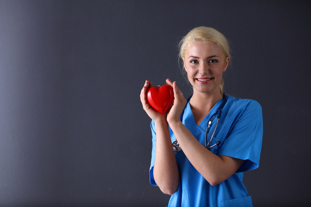 Doctor with stethoscope holding heart - Valokuva, kuva