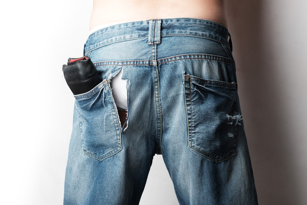 un homme porte un jean avec des traces de theif refendage sur elle
 - Photo, image
