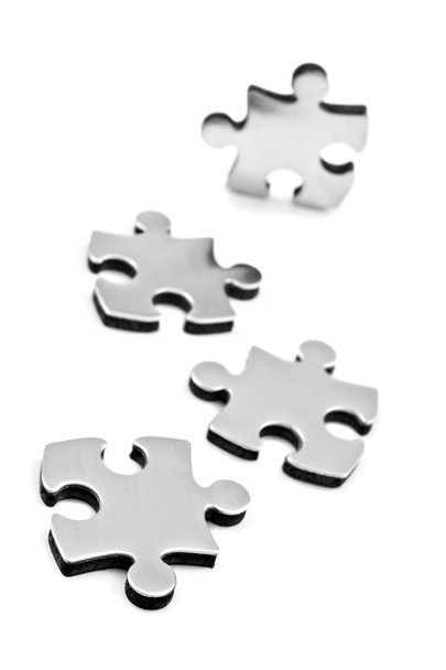 Aço inoxidável quebra-cabeças peças no fundo branco
 - Foto, Imagem