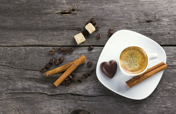Cup of coffee with cinnamon and sugar on a wooden background - Foto, afbeelding