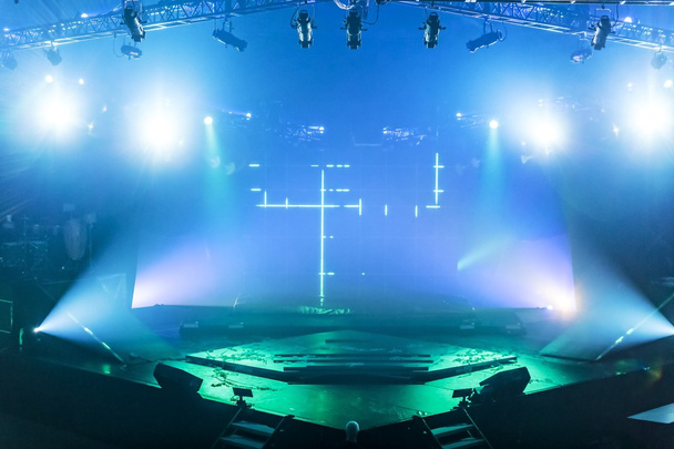 Um palco de desempenho vazio com luzes verdes e azuis iluminando a área. - Foto, Imagem