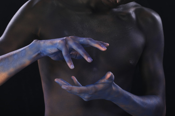 body art tinted black man's hands on the background of male body - Zdjęcie, obraz