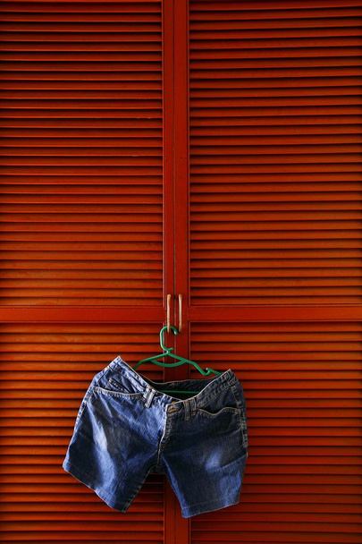 Short en denim suspendu par une porte d'armoire à vêtements
 - Photo, image
