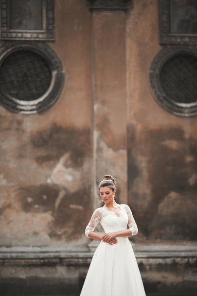 Wonderful bride with a luxurious white dress posing in the old town - Foto, Bild