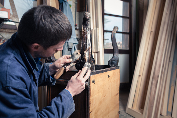 Carpintero restaurando muebles de madera con yeso y masilla Knif
 - Foto, imagen