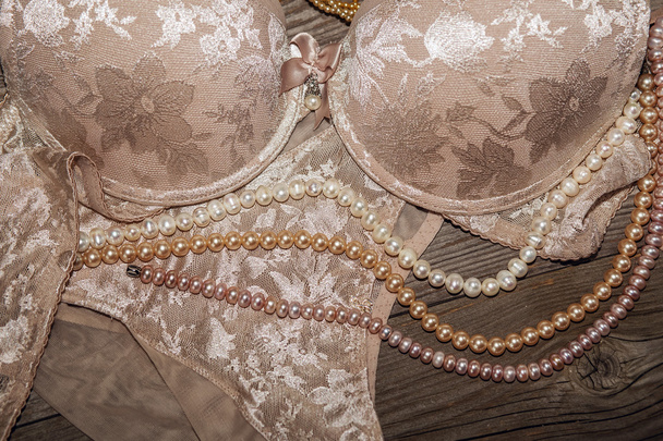 Sexy lace lingerie and pearls on a wooden board.  - Photo, Image