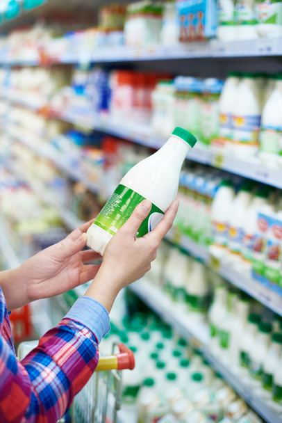 Mujer comprando leche en la tienda
 - Foto, Imagen