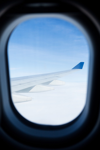 Σύννεφα μέσα από το παράθυρο του αεροπλάνου - Φωτογραφία, εικόνα