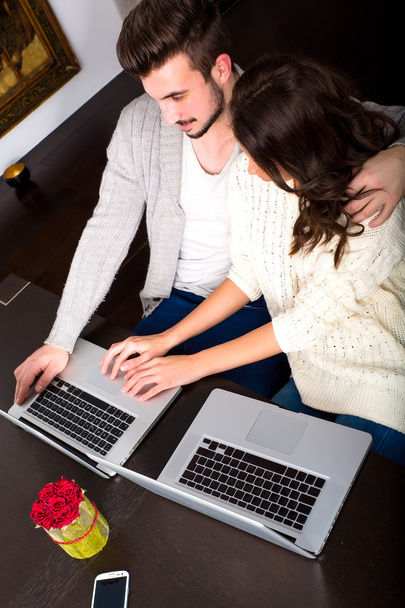 Young couple in front of their Laptop Computers at home - Foto, afbeelding