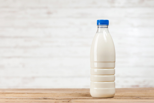 Butelka mleka na drewnianym stole - Zdjęcie, obraz