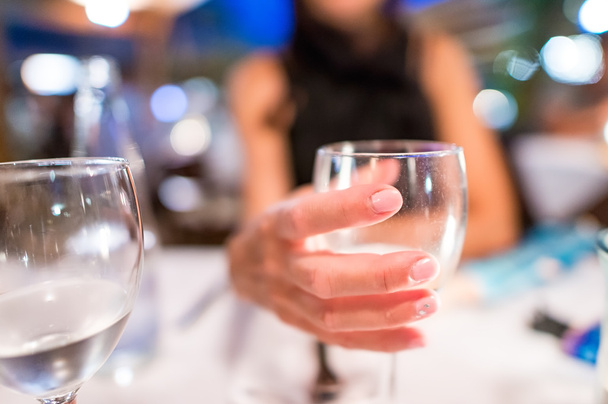 Woman hand holding wine glass at restaurant - Foto, Imagem