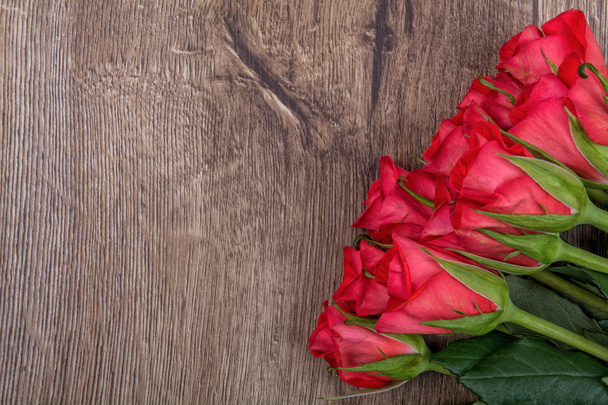 Red roses on a wooden background - Photo, Image