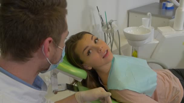 Happy Patient of a Dental Clinic Gets up Dentist in Mask is Shaking a Client's Hand Woman is Going to Leave Dental Treatment Room Visit to the Dentist - Záběry, video
