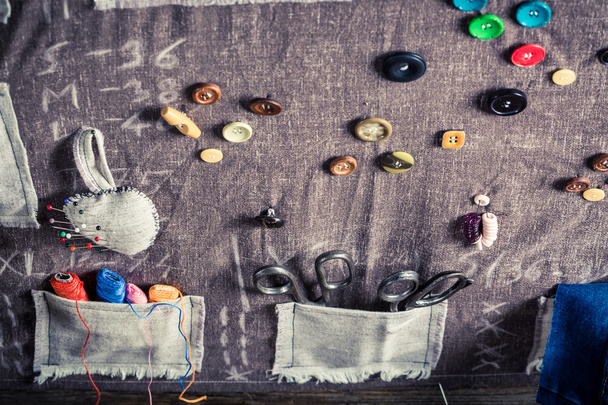 Tapis de couture fait à la main avec ciseaux, aiguilles et fils dans un atelier de tailleur
 - Photo, image