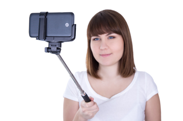 young beautiful woman taking photo on smart phone with selfie st - Foto, Imagem