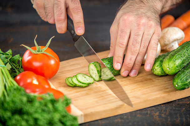 Male hands cutting vegetables for salad - Photo, Image