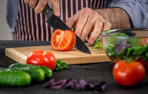 Male hands cutting vegetables for salad - Foto, imagen