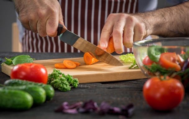 Male hands cutting vegetables for salad - Valokuva, kuva