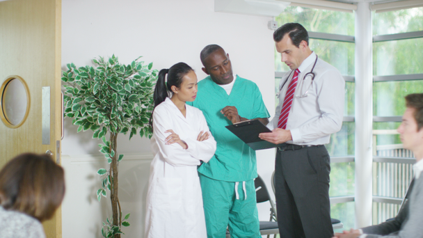 trabajadores médicos discutiendo las notas de un paciente
 - Metraje, vídeo