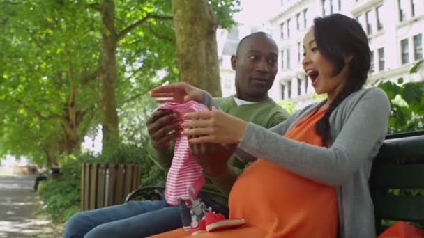 paar nemen de kleren van de baby uit boodschappentassen - Video