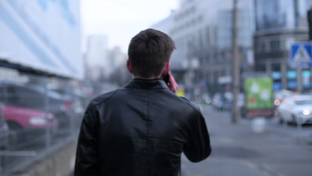 Homme brune parlant sur une cellule traversant la ville
 - Séquence, vidéo