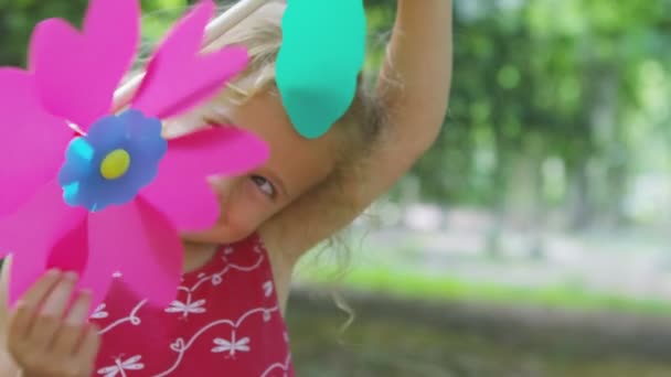 girl playing  with a pinwheel toy - Filmati, video