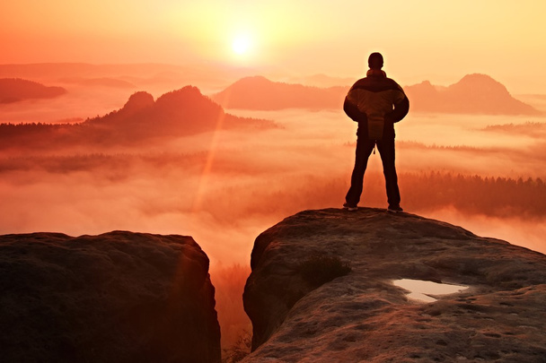 Hombre en el pico de roca arenisca en el parque nacional Sajonia Suiza mirando al Sol. Hermoso momento
 - Foto, imagen