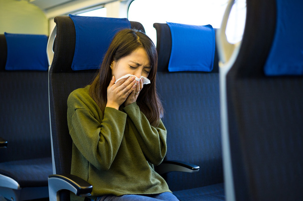woman sneezes in train compartment - Photo, Image