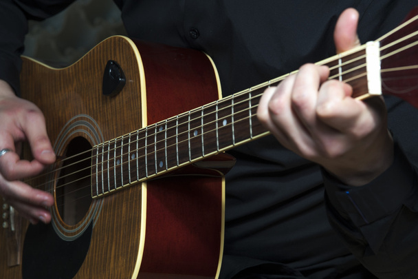 Closeup of man's hands playing on guitar - Foto, imagen