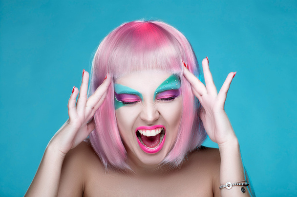 Hij schreeuwen Sexy meisje met creatieve make-up en roze haren touch - Foto, afbeelding