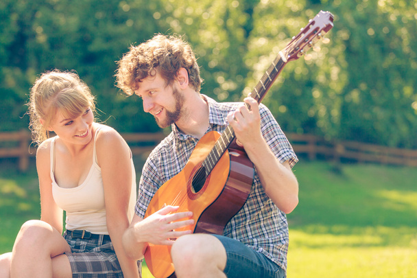 Young couple camping playing guitar outdoor - Foto, Imagen