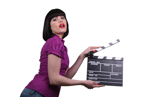 Woman holding up a clapperboard - Photo, Image