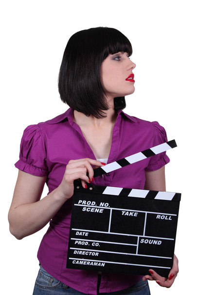 Attractive woman with a clapperboard - 写真・画像