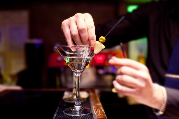 Le barman décore la verrerie avec du martini
 - Photo, image