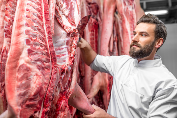 Butcher cutting pork at the manufacturing - Foto, Bild