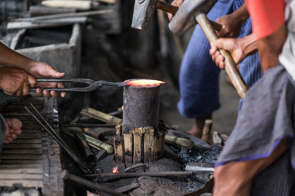 Detalle plano de martillo forjando hierro caliente en yunque
 - Foto, imagen