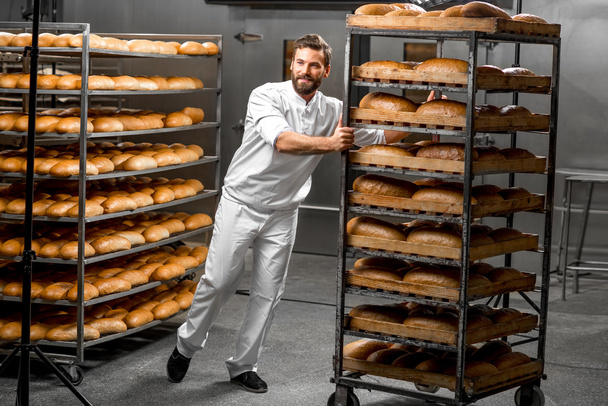 Pracownik prowadzenie półki z chleba - Zdjęcie, obraz